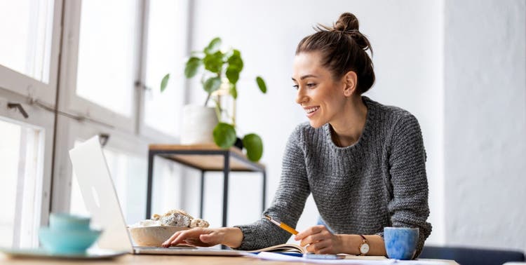 La imagen muestra a una mujer en una computadora portátil. que funciona con un archivo XLSM.