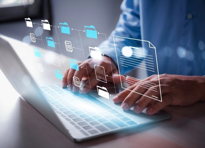 Foto: Una persona en un ordenador portátil abre varios documentos de texto mediante una máscara digital.