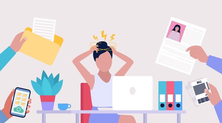 Una mujer está trabajando con su portátil y se siente abrumada porque tiene que hacer varias tareas al mismo tiempo