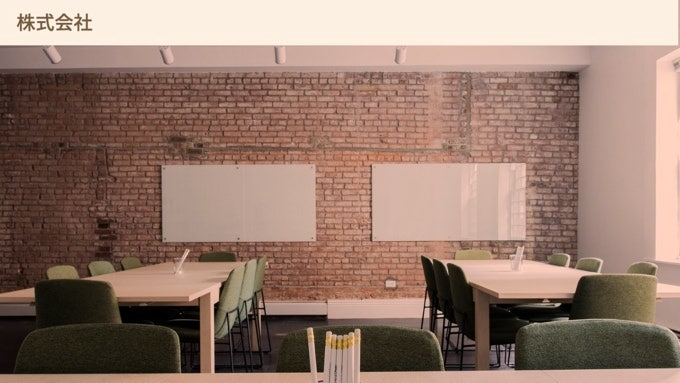 Zoom background of an office with tables, chairs, and white boards with a brick wall in the background