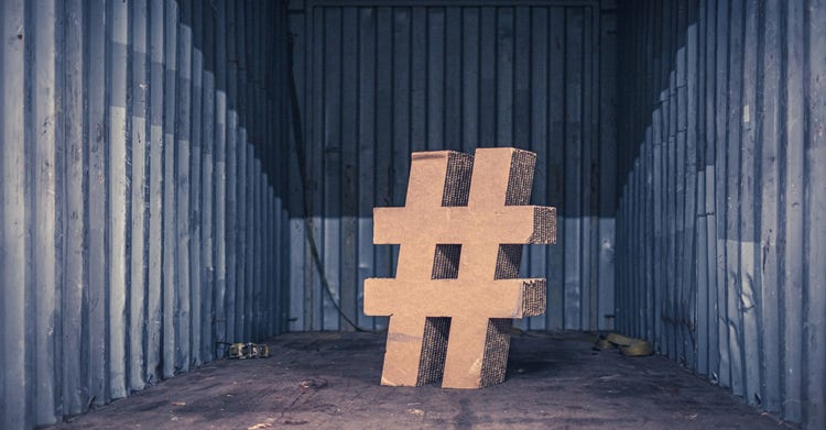 Large wooden hashtag symbol standing in the center of an empty metal storage unit.