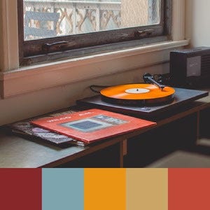 A color palette created from an image of a record player with an orange record and a red record cover near a window