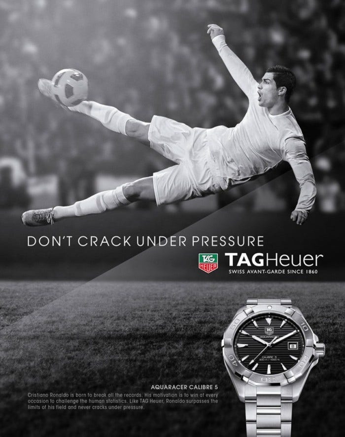 A black and white soccer player jumping sideways kicking a ball with Tag Heuer's slogan a watch below