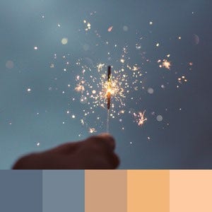 A color palette created from an image of a hand holding a sparkler against a blue-grey sky