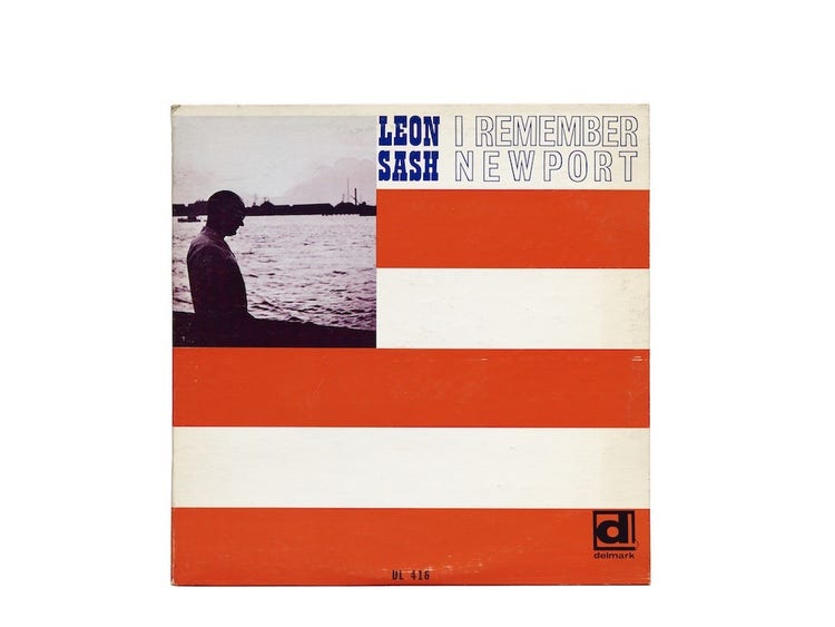 An album cover that resmbles the American flag with thick white and orange horizontal stripes from top to bottom and a sihlouettted portrait of a man on a body of water at the top left.