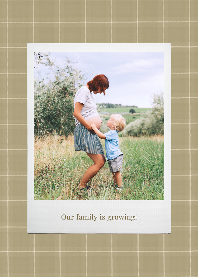 "Our family is growing!" green plaid pregnancy announcement with an image of a child touching a pregnant person's belly in a field