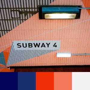 A color palette created from an image of a "Subway 4" sign that is painted on a white tiled wall in orange and blue