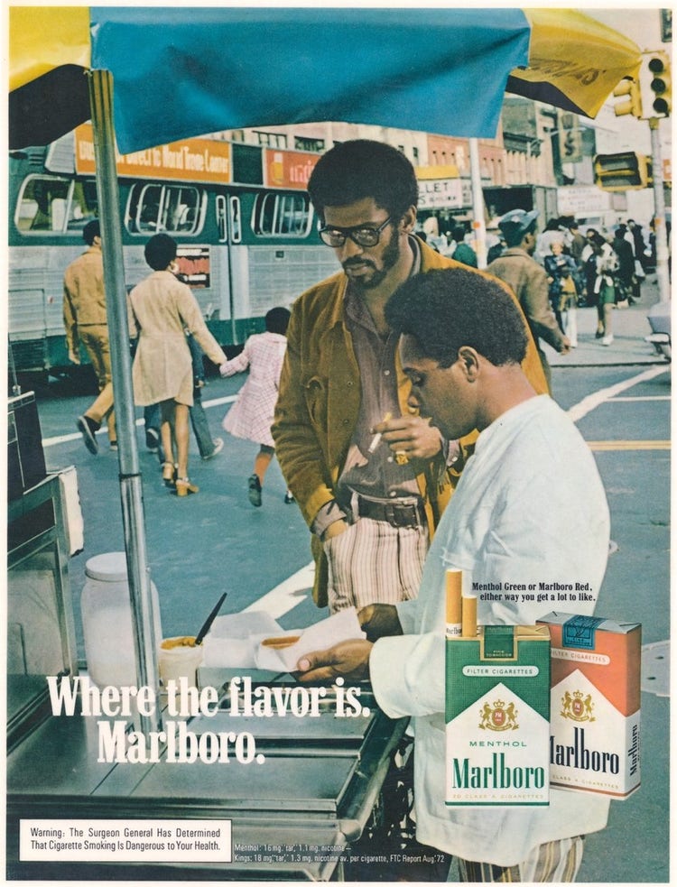 Colorful advertisement featuring two Black men outside, one of whom is servering food from a street cart and another who is smoking a cigarette. Marboro cigarettes are laid over the photograph at the bottom of the ad, as well as the tagline "Where the flavor is. Marlboro."