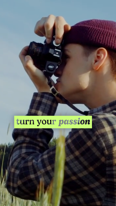 Image of a man in a burgandy wool cap and flannel shirt taking a picture with a camera.