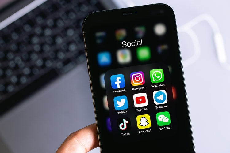 Various social media platforms on a phone screen – Facebook, Instagram, Twitter, YouTube, TikTok, Snapchat, and more