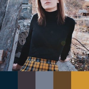 A color palette created from an image of a person wearing a black shirt and a yellow plaid skirt posing against a grey and brown wall