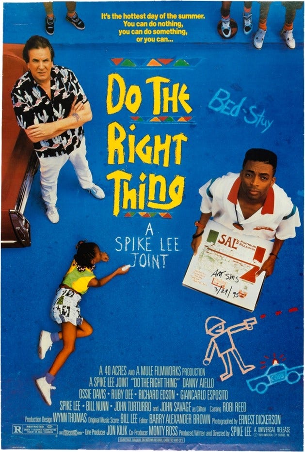 A Black man holds a pizza box at right, and a white man stands with his arms crossed at left, both looking at the viewer. A Black child writes with chalk on the ground, which is part of the movie's title.