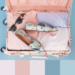 A color palette created from an image of an open pink suitcase with pink and blue clothing, sunglasses, and blue floral shoes