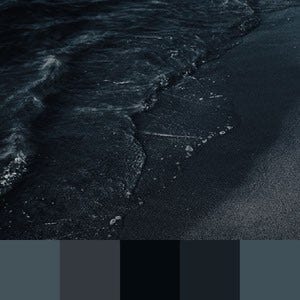 A color palette created from an image of water washing over a black sand beach