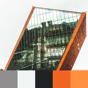 A color palette created from an image of a grey, white, and black building with orange sides and reflective windows