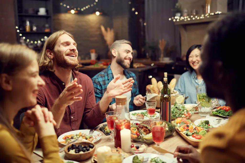Adobe Stock photo example: People laughing at dinner party