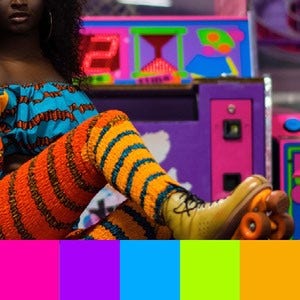 A color palette created from an image of a person in neon leg warmers and roller skates with a neon arcade game in the background