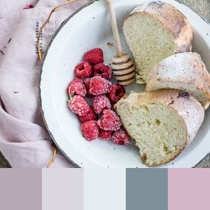A color palette created from an image of bread with honey and raspberries in a white bowl on a lavender sheet