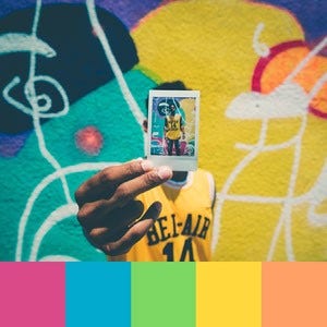 Color palette created from an image of a person holding a polaroid in front of yellow, blue, pink, green, and orange wall art