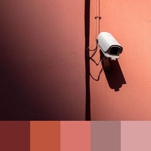 A color palette created from an image of a white security camera against a salmon colored wall partially cast in shadows