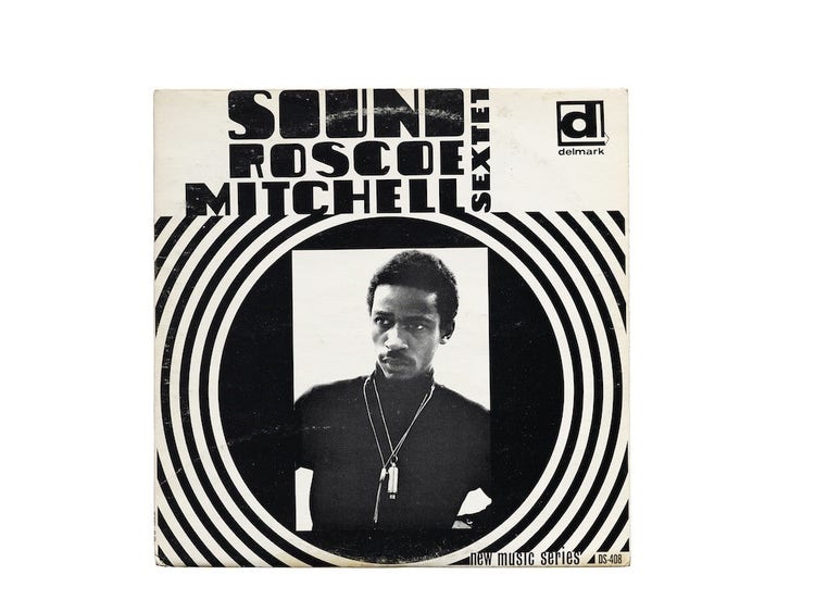 An album cover with a black and white portrait of a Black man in a turtleneck at center. The potrait is embedded in a black circle and curved lines emanate out from it.
