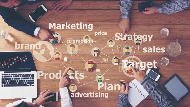A team working together to create a marketing plan by identifying what they need to include – products, advertising, strategy, etc.