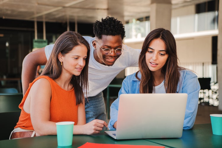 Groupe d'étudiants devant un ordinateur en train de relire une introduction de mémoire.