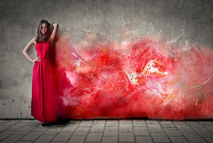 Photo d’une femme porte une robe écarlate devant un mur gris et rouge