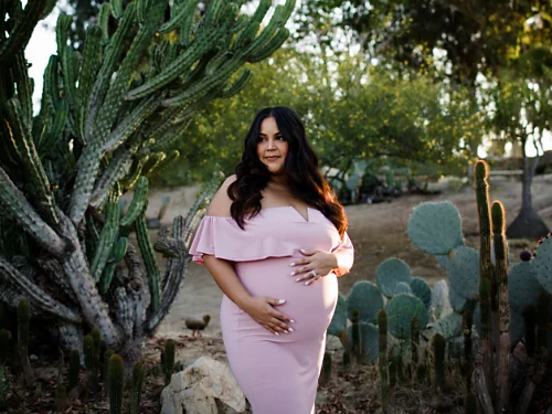 A solo maternity portrait taken in a cactus garden.