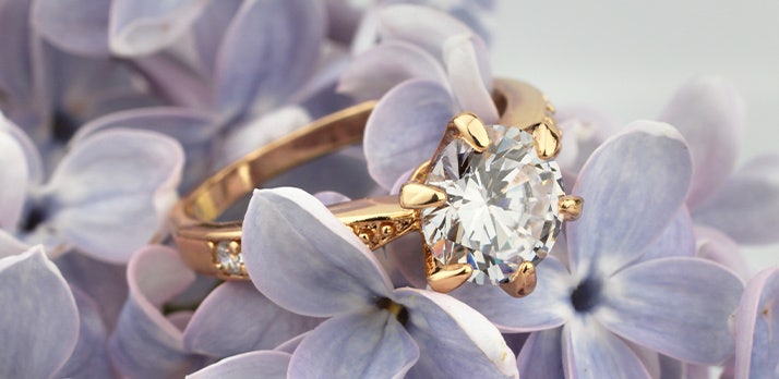 Macrophotographie d’une bague en diamant posée sur un lit de fleurs de lavande