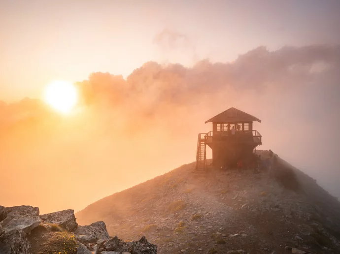 Soleil perçant à travers les nuages et éclairant une cabane de secouriste sur le rivage