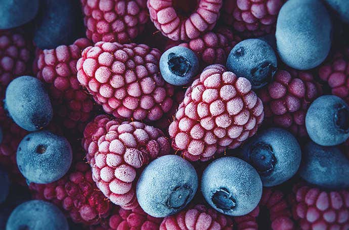 Macrophotographie de framboises et myrtilles congelées