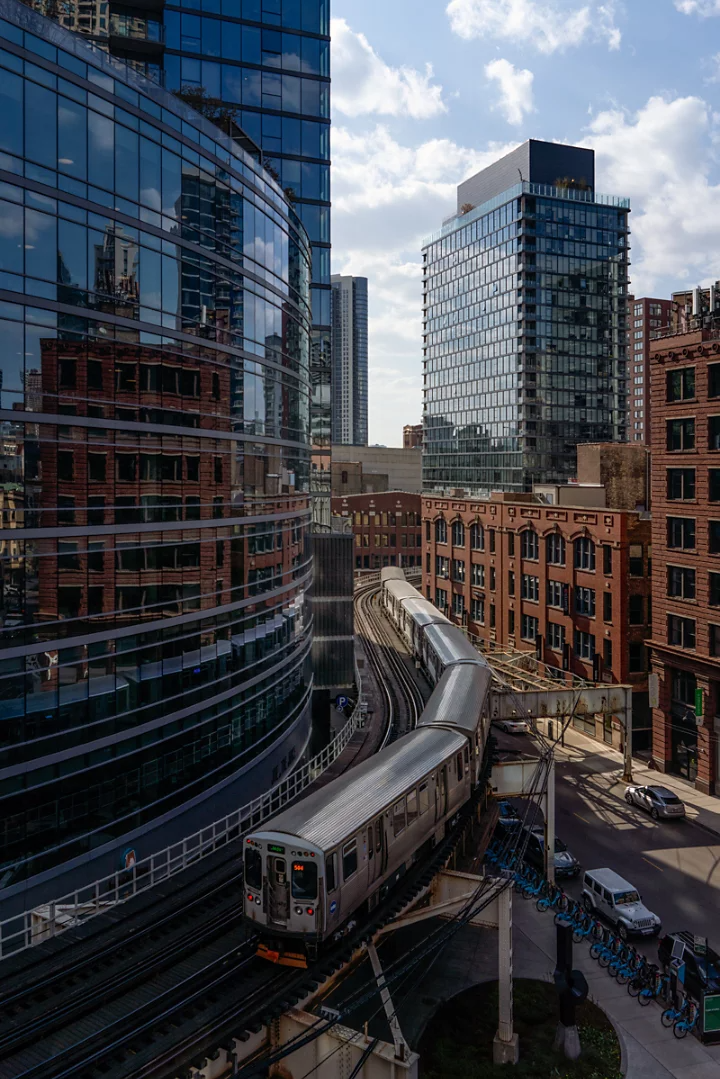 Un métro aérien serpente sur des rails incurvés épousant le contour d’un immeuble