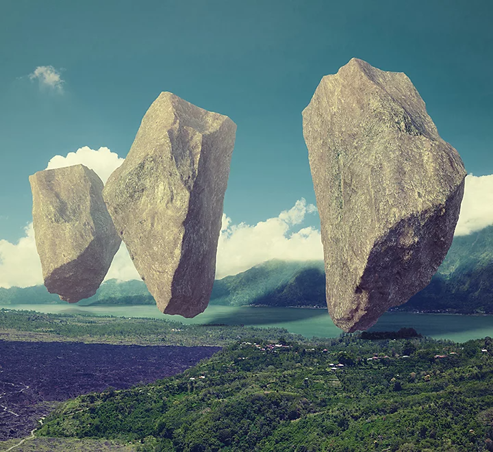 Photo surréaliste de rochers flottant au-dessus d’un paysage