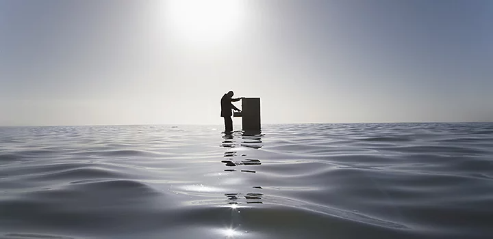Personne flottant au milieu de l’océan et ouvrant une commode