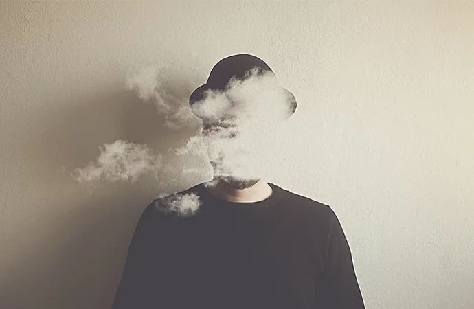 Photo surréaliste d’un nuage de fumée couvrant le visage d’une personne
