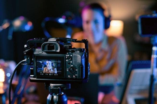 A person using a camera to create a video podcast