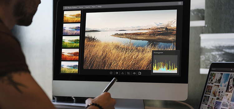 Hombre usando la herramienta Histograma para editar la foto de un paisaje
