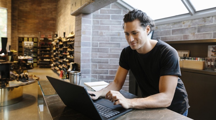 A person sitting at a table using their laptop