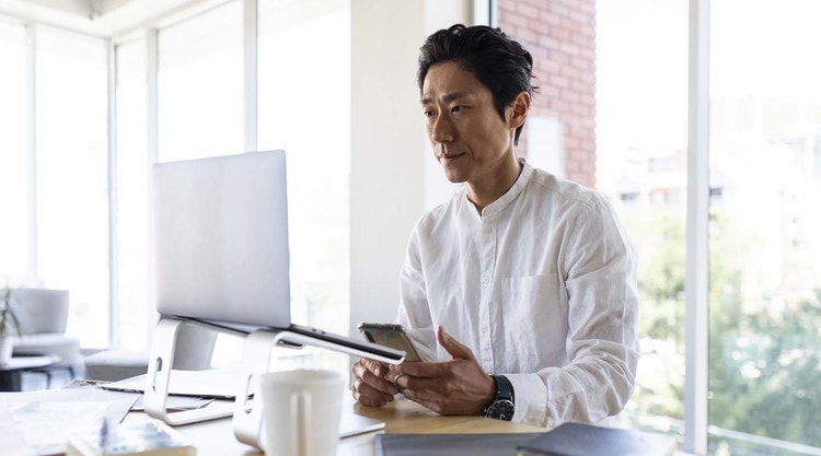 A person organizing digital documents on their smartphone and laptop