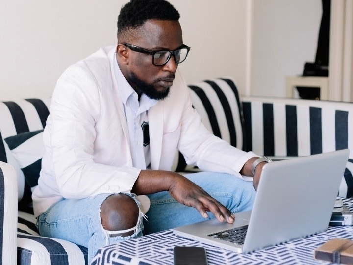 A business person reviews a digital workflow on a laptop