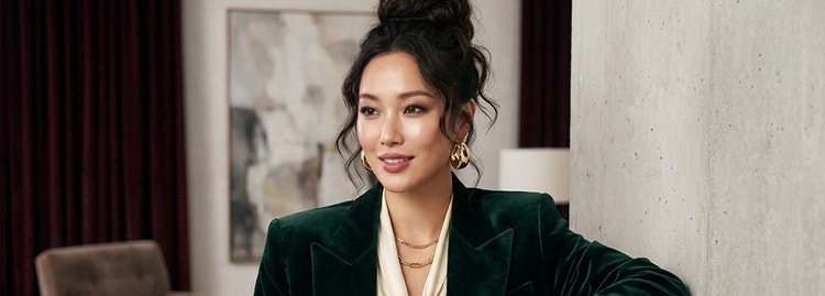 一張 AI 產生的年輕女性人像，紮著隨性丸子頭，穿著時尚服裝，背景為風格化的室內空間。