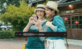 Two travelers use an audio translator on a smartphone showing translate audio waveform while exploring a new destination.