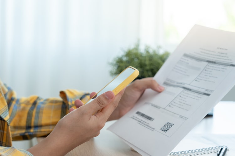 Single hand taking a screen shot of an invoice from the mobile phone, showcasing invoice app capabilities
