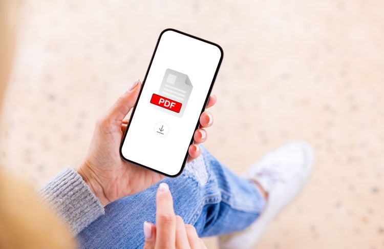 Person holding a smartphone displaying a PDF file download icon on the screen, representing mobile PDF access and document management.