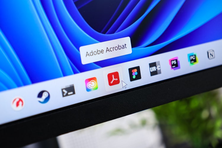 Adobe Acrobat icon highlighted on the Windows 11 taskbar with a cursor hovering, indicating user interaction.