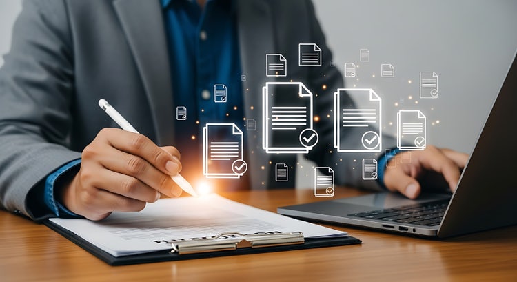 Business professional digitally signing multiple documents on paper and laptop with icons of approved files. Concept of how to sign all pages in PDF at once, apply multiple digital signatures in PDF, use bulk digital signature in PDF workflows, and how to add DSC in PDF for compliance.