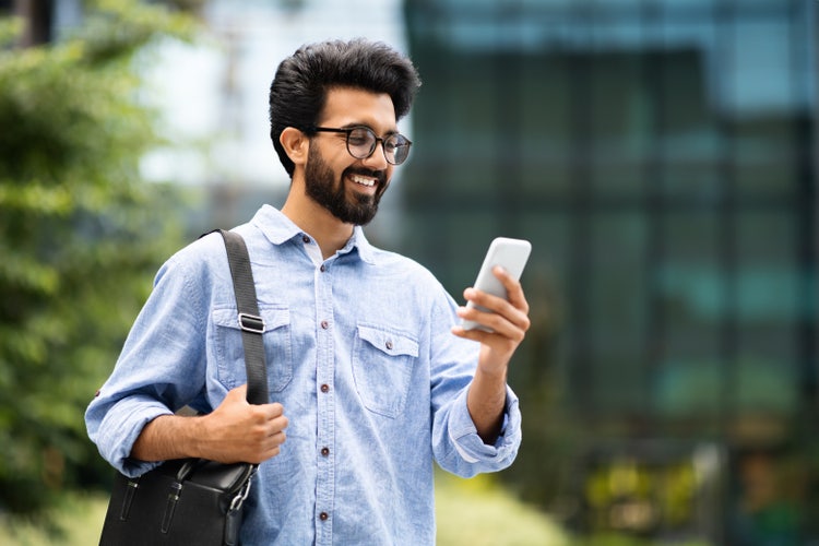 A young creative using his mobile phone to check on work-related documents while on the go.