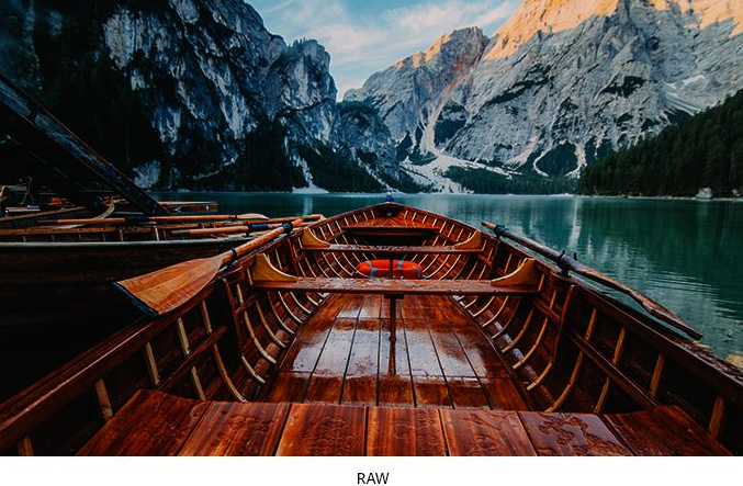 A raw vs. corrected photo of a wooden boat on a mountain lake