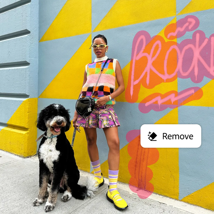 A woman and dog standing in front of a wall with graffiti on it